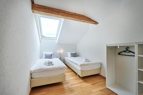 two beds in a small room with a window at Aparthotel Krone - Self Check-In in Interlaken