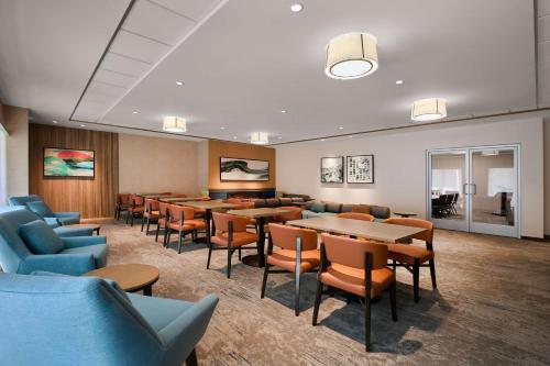 a waiting room with tables and chairs at Hilton Garden Inn LAX Los Angeles Airport in Los Angeles