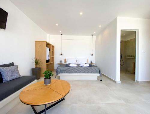 a living room with a bed and a table at Nohēme Luxury Suites in Vourvoulos