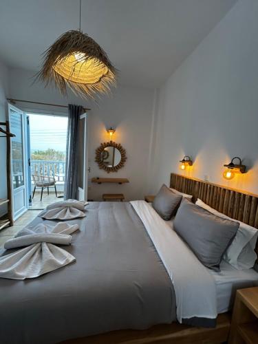 a bedroom with a large bed with a large window at Hotel Livadia in Parikia