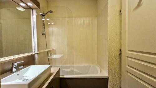 une salle de bain avec un lavabo et une baignoire dans l'établissement Résidence Les Terrasses De Veret - Appartement confortable · Au pied des pistes · Piscine · Spa · Parking inclus MAE-7391, à Flaine