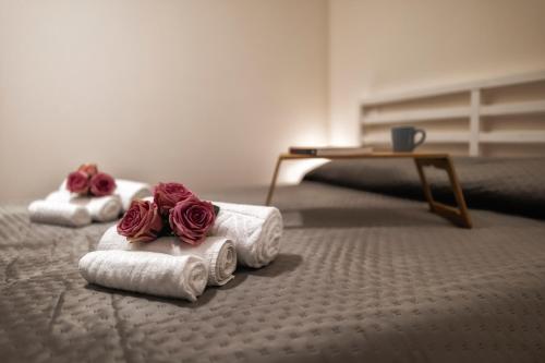 two rolled up towels with red roses on the floor at Boccaccio Apartment 2 in Ravenna