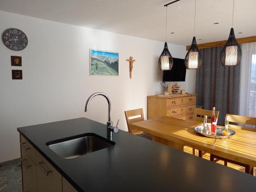 a kitchen with a sink and a wooden table at High-quality holiday apartment in Oberkrimml near waterfalls in Krimml