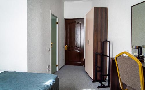 a room with a bedroom with a door and a bed at Chaika Gostinichny Kompleks in Karagandy