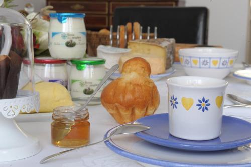 une table recouverte d'assiettes, de tasses et de beurre dans l'établissement Au Coeur De Beauvais, à Beauvais