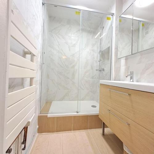 une salle de bain avec douche et lavabo dans l'établissement L'Ancre - Spacieux T4 élégant et lumineux vue mer, à La Baule