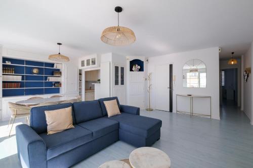 un salon avec un canapé bleu et une table dans l'établissement L'Ancre - Spacieux T4 élégant et lumineux vue mer, à La Baule