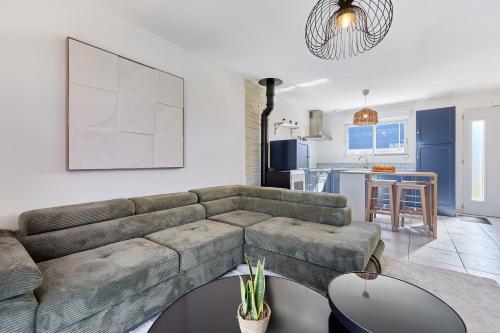 un salon avec un canapé et une cuisine dans l'établissement Les Embruns du Clos - A 1 km des rives de la Seine, à Berville-sur-Mer