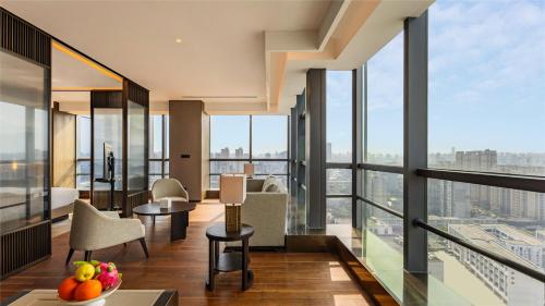 a room with floor to ceiling windows and a view of a city at New Century Mansion Hotel Changzhou in Changzhou