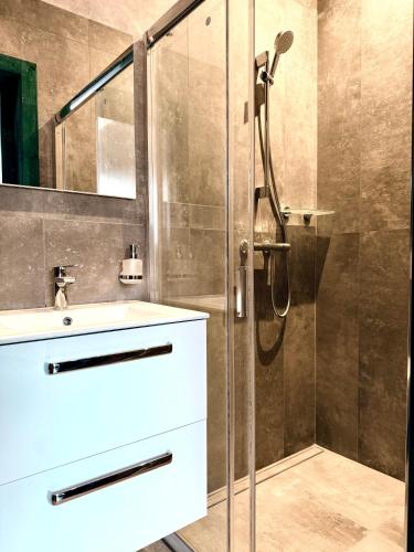 a bathroom with a shower and a white sink at CARLA comfort stay with 2 bathrooms in Košice