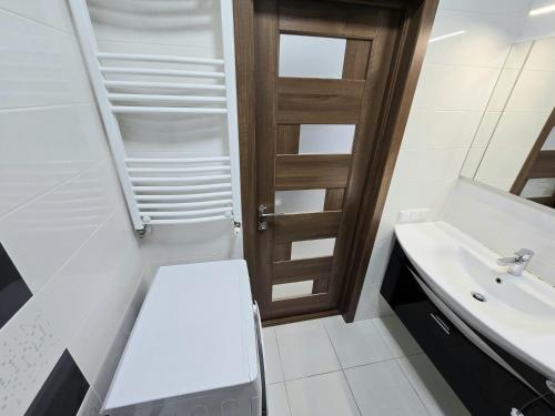 a bathroom with a sink and a wooden door at King-size bed and living room apartment in Chişinău