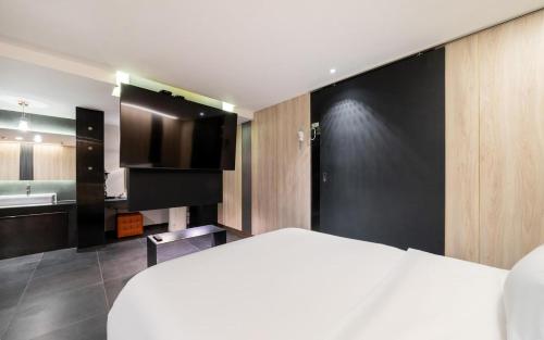 a bedroom with a white bed and a bathroom at Yeoksam Lumiere Hotel in Seoul