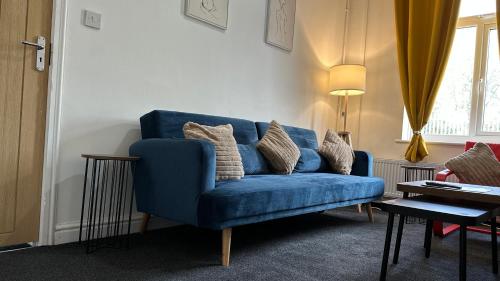 a blue couch sitting in a living room at The Ol-Mumps Cozy Corner in Oldham