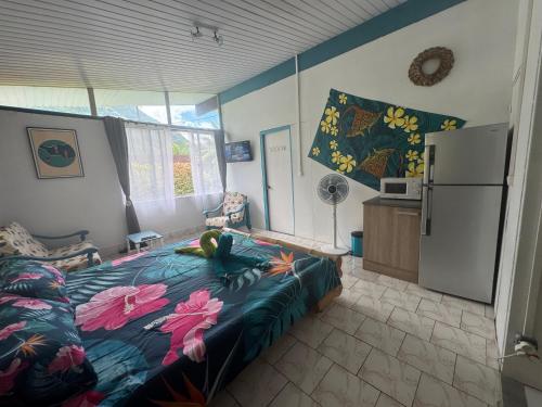 a bedroom with a bed and a refrigerator at Blue Moana Lodge in Papara