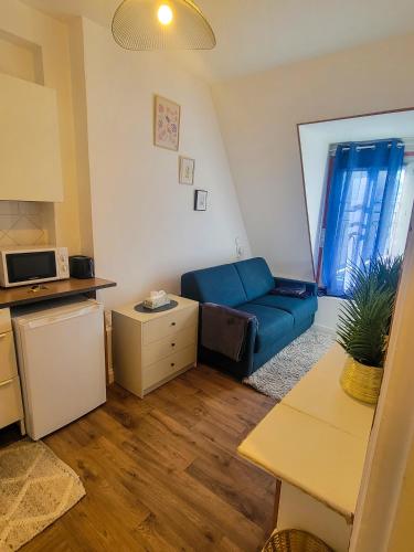 un salon avec un canapé bleu et une cuisine dans l'établissement Paris 16 Appartement avec vue sur la tour eiffel, à Paris