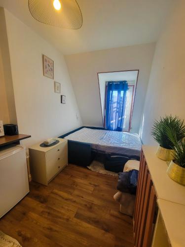 une petite pièce avec un lit et une fenêtre dans l'établissement Paris 16 Appartement avec vue sur la tour eiffel, à Paris