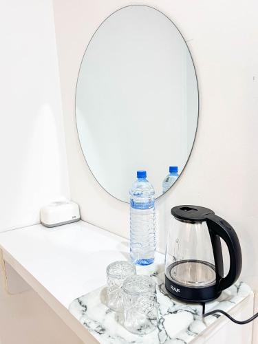 a bathroom counter with a mirror and a tea kettle at Aquatic Mathiveri in Mathiveri