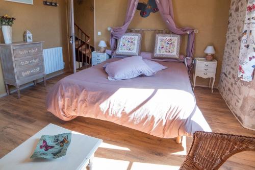 a bedroom with a large bed with a canopy at Ecuries de Saint Maurice- Maison d'hôtes de Gondou in Lacapelle-Marival