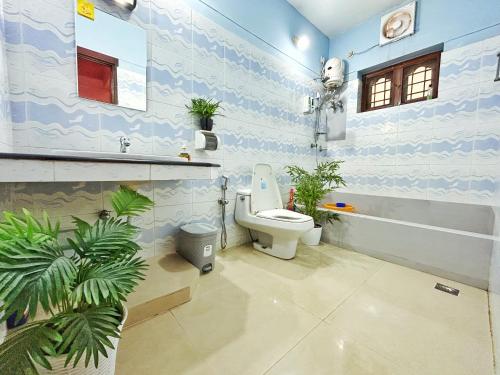 a bathroom with a toilet and plants in it at La Casa Trivandrum 4 BHK AC Luxury Villa at City Centre, Just 5 kms from Airport & 3 Kms to Trivandrum Railway Station in Trivandrum