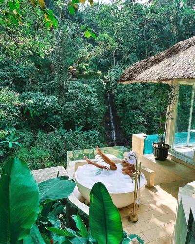 a bathroom with a bath tub in the middle of a forest at Villa Cella Bella Ubud in Ubud