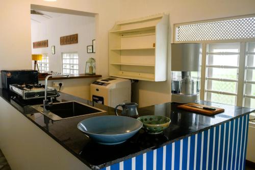 a kitchen with a sink and a bowl on a counter at Magnolia House Mirissa in Mirissa