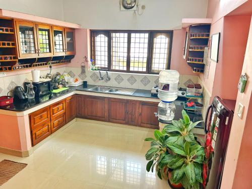 a large kitchen with wooden cabinets and a sink at La Casa Trivandrum 4 BHK AC Luxury Villa at City Centre, Just 5 kms from Airport & 3 Kms to Trivandrum Railway Station in Trivandrum