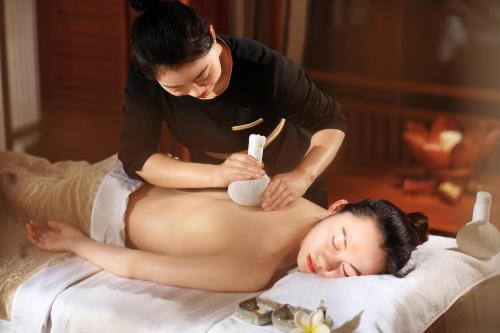 a woman getting a massage from a therapist at InterContinental Halong Bay Resort by IHG in Ha Long