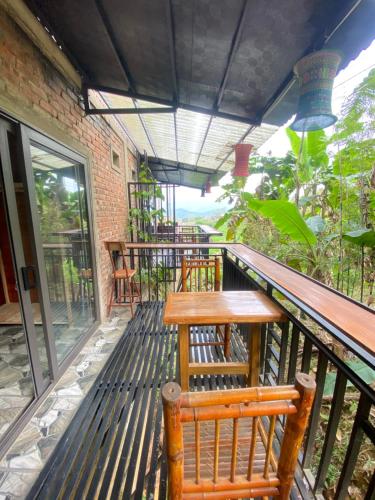 a balcony with wooden benches and a wooden table at House By The Stream in Lũng Tiềm