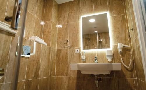 a bathroom with a sink and a mirror at Chaika Gostinichny Kompleks in Karagandy