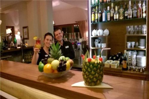 a man and woman behind a bar with a bowl of fruit at Wy & Spa in Pobierowo