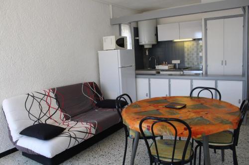 un salon avec un canapé et une table avec des chaises dans l'établissement Appartement 2 pièces PORT LA NOUVELLE PN240-001, à Port-la-Nouvelle