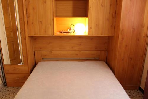 Cette petite chambre comprend un lit dans un meuble en bois. dans l'établissement Appartement 2 pièces PORT LA NOUVELLE PN240-001, à Port-la-Nouvelle