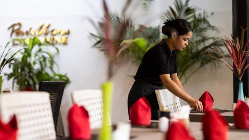 a woman standing in front of a table at Pavillon Indochine Boutique - Hotel in Siem Reap