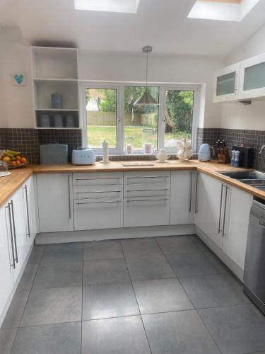 a kitchen with white cabinets and a large window at 4 Bedroom Detached House Sleeps 7 in Ipswich