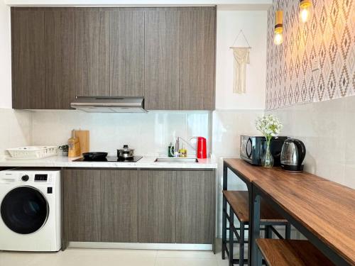 a kitchen with a stove and a sink and a microwave at Greenfield Residence Bandar Sunway in Petaling Jaya