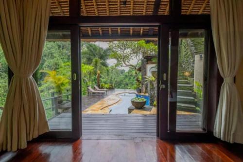 an open door of a house with a view of a garden at Villa Cella Bella Ubud in Ubud