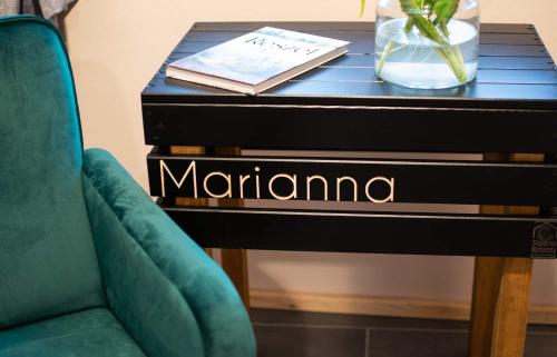 a table with a green chair next to a table with a piano at Kamienica Marianna in Reszel