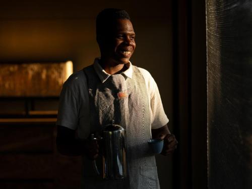 a man standing with a cup in his hand at Amaya in Hoedspruit