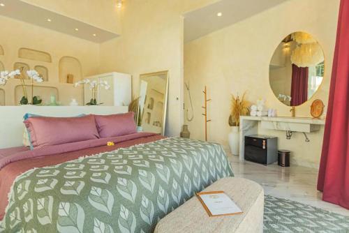 a bedroom with a large bed and a mirror at Villa Cella Bella Ubud in Ubud