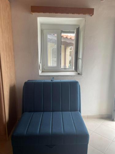 a blue couch in a room with a window at Stella's Studio in Tsimándria