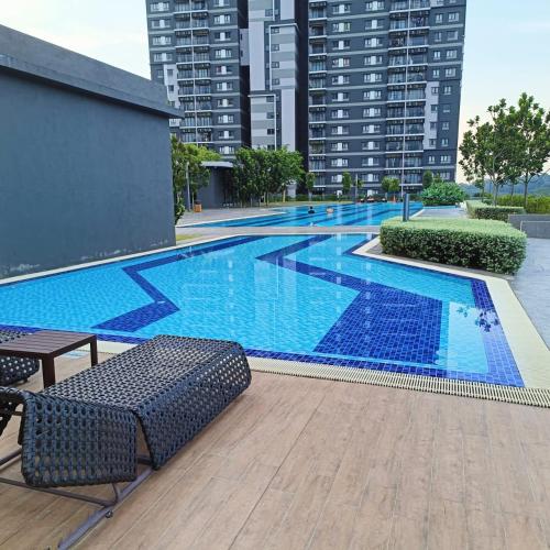ein großer Pool mit Stühlen und Gebäuden in der Unterkunft Rania Homestay Sensory in Kajang