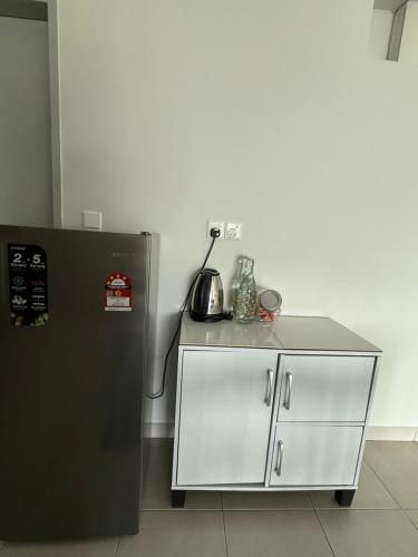 a kitchen with a counter next to a refrigerator at The Barakat Homestay in Semenyih