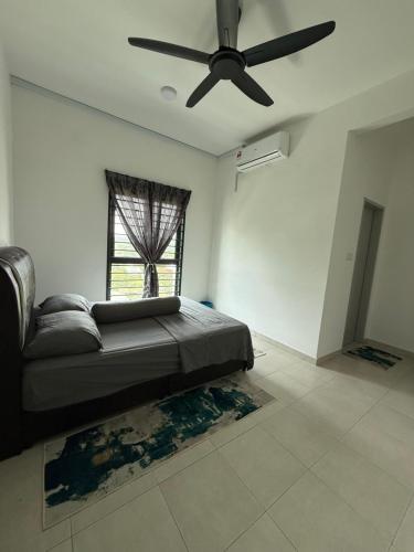 a bedroom with a couch and a ceiling fan at The Barakat Homestay in Semenyih