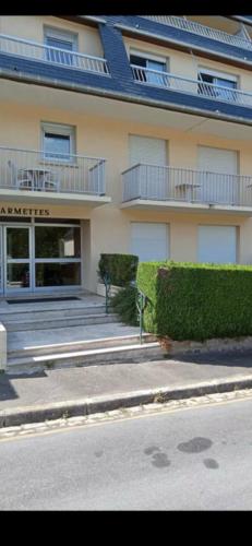 un grand bâtiment avec un balcon sur le côté d'une rue dans l'établissement Studio au calme avec stationnement, à Bagnoles-de-l'Orne