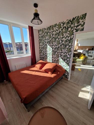 - une chambre avec un lit doté d'oreillers rouges dans l'établissement Appartement le ara, à Auxerre