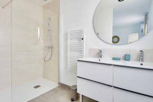 ein weißes Badezimmer mit Dusche und Waschbecken in der Unterkunft Jolie maison pour 8 - 400m de la plage - terrasse in La Guérinière