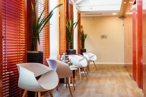 a row of white chairs and tables in a room at Grand Hotel des Bains in Lavey-les-Bains