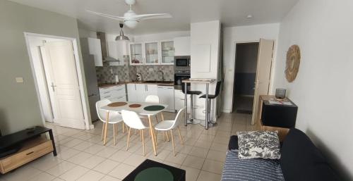 a kitchen and a living room with a table and chairs at T2 TOUT CONFORT La POSSESSION PROCHE ROUTE DU LITTORAL in La Possession