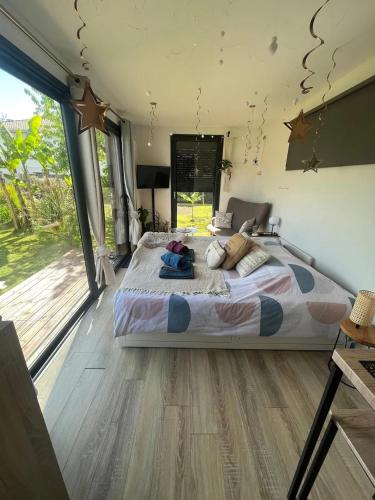 une chambre avec un grand lit et une grande fenêtre dans l'établissement Chalet accueillant à Saint-Vincent-de-Tyrosse avec jardin, à Saint-Vincent-de-Tyrosse