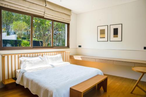 a bedroom with a bed and a window at Tree O'clock Pool Villa - Phuket in Thalang